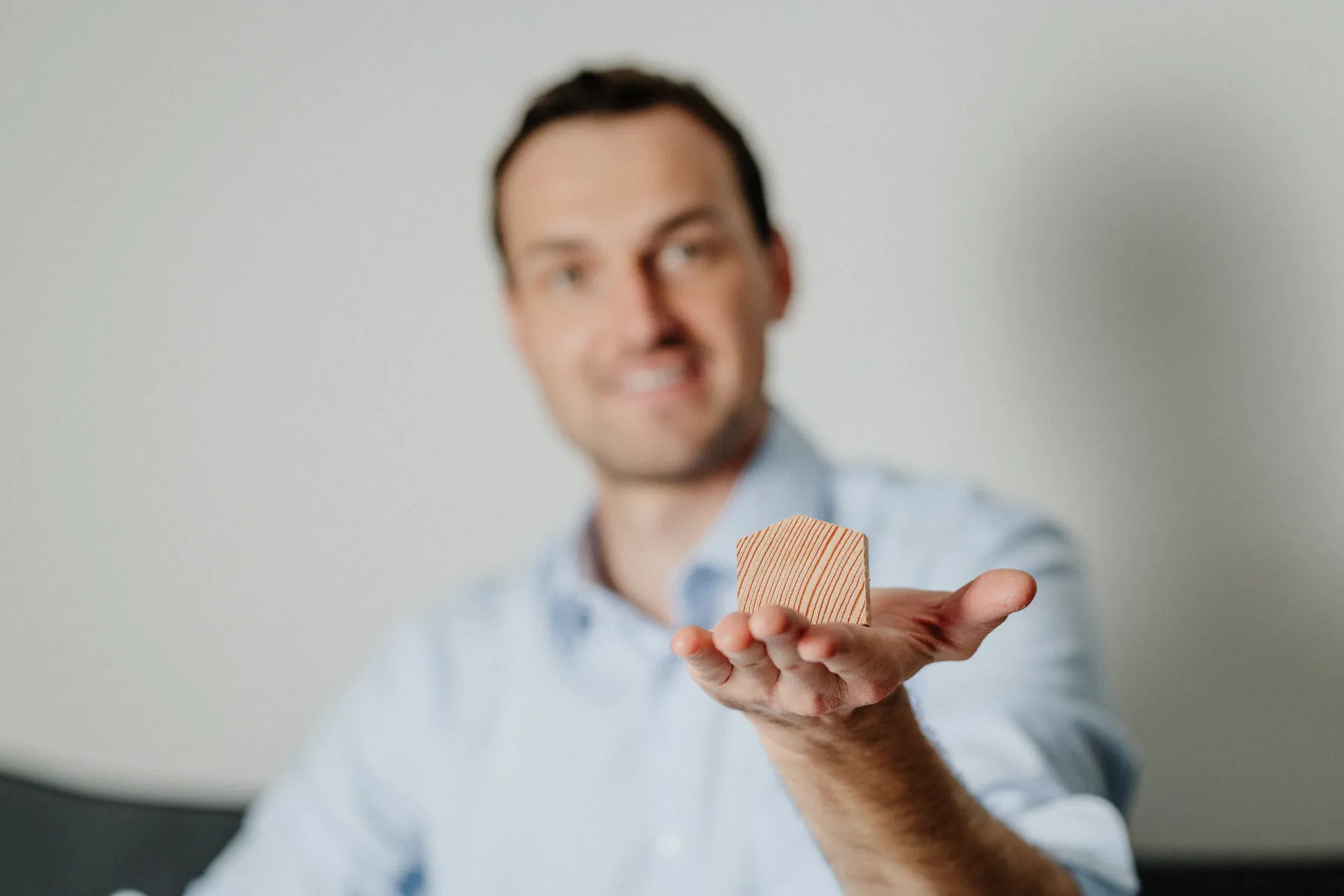 Thomas Griessner hält ein kleines Holzhaus als Symbol für das Eigenheim in der Hand
